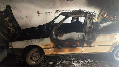 Carro pega fogo em garagem de residência