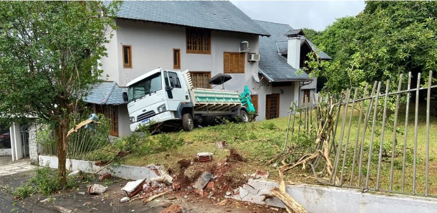Caminhão da Casan perde freio, atinge carro e derruba muro