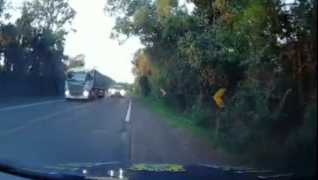Motorista tenta ultrapassar carreta em curva e quase colide de frente com viatura PRF
