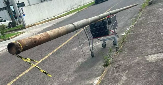 Homens carregam poste furtado em carrinho de supermercado