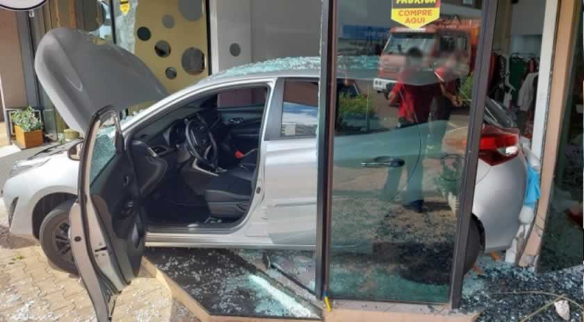 Em marcha à ré, veículo atravessa rua e invade loja no centro